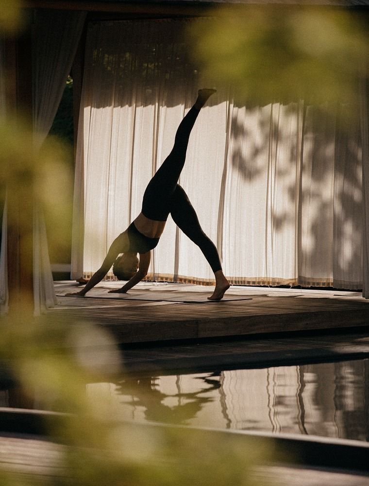Guest practising yoga beside the pool at SOMA