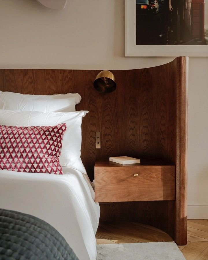 Bed with patterned cushions and bedside table at SOMA